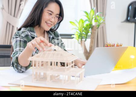 Architects working on a house model in a creative office. Stock Photo