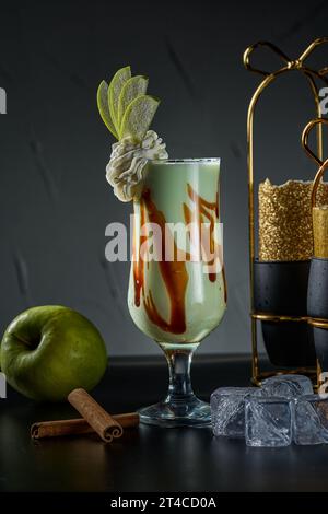 Picture of an apple smoothie cup on a black background and ice cubes Stock Photo