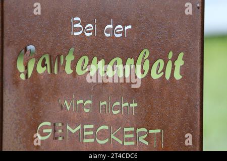 garden sign with the writing 'Bei der Gartenarbeit wird nicht gemeckert!', Germany Stock Photo