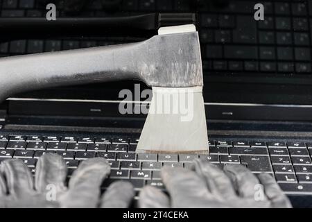 hands with gloves typing on laptop keyboard with ax, data contamination Stock Photo