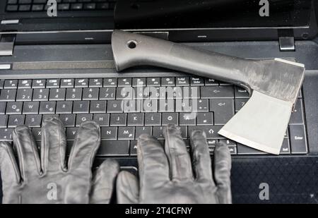 hands with gloves typing on laptop keyboard with ax, data contamination Stock Photo