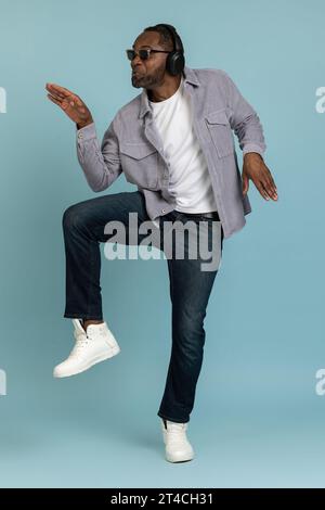 Funny guy listens lively music modern stereo headphones moving dancing Stock Photo