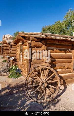 An old original wooden wagon wheel by a cabin at the Bluff Fort Historic Site in Bluff, Utah. Stock Photo