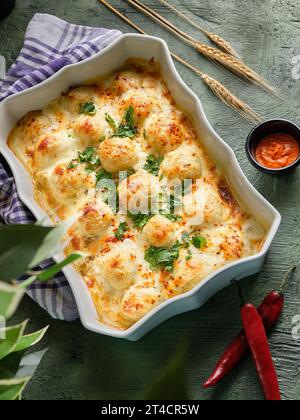 Cheese plate and potatoes in the oven on a green background Stock Photo