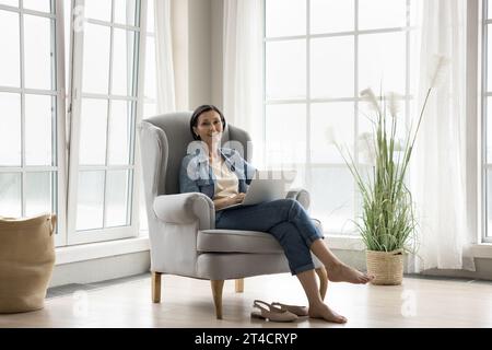 Cheerful happy mature freelancer woman using laptop Stock Photo