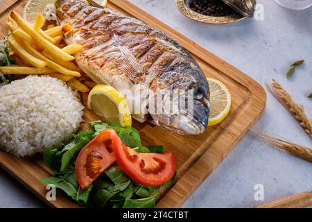Grilled fish in the oven with rice and leafy vegetables Stock Photo