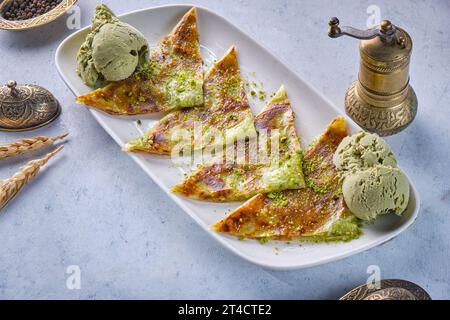 Katmer Turkish dessert with pistachio ice cream on Gray background Stock Photo