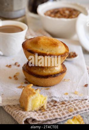 Pasticciotto leccese pastry filled with egg custard cream, typical sweet from Lecce, Italy. Pieces of pasticiotto on a beige napkin, apulian breakfast Stock Photo