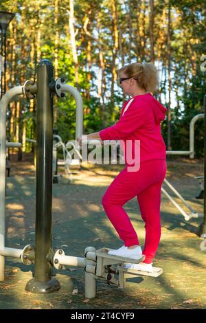 Fitness, sport, training and lifestyle concept - senior woman doing exercises outdoors Stock Photo