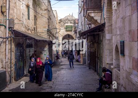 The arab people, including veiled Muslim women going down the streets of Muslim quarter of Jerusalem Old Town in Israel. Stock Photo