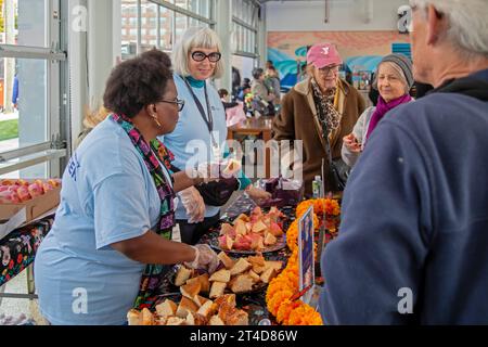 Detroit, Michigan - Day of the Dead celebration at Valade Park on the Detroit Riverfront. Volunteers distributed Pan de Muerto, or bread of the dead. Stock Photo
