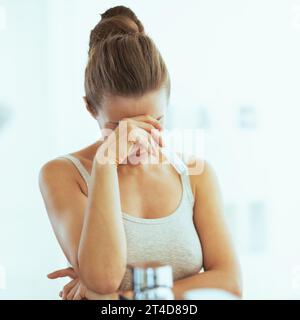 Concerned young woman with pregnancy test in bathroom Stock Photo