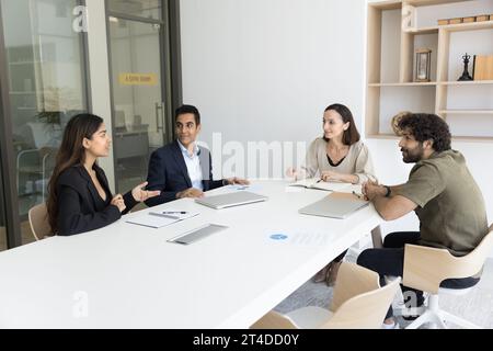 Business colleagues of different ages talking at meeting table Stock Photo