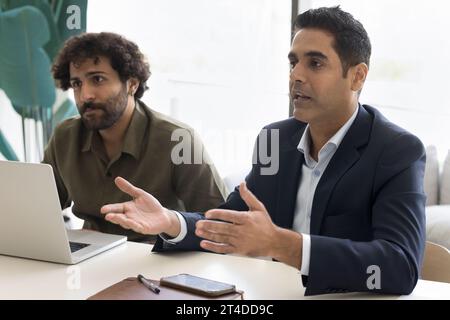 Serious Indian businessman in formal jacket talking partners Stock Photo