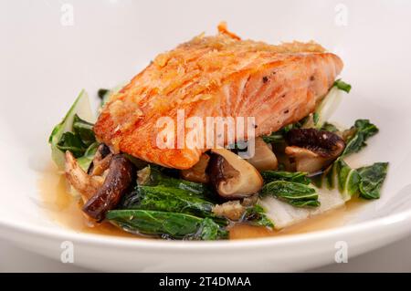 Cooked wild salmon on a bed of mushrooms and cabbage. Stock Photo