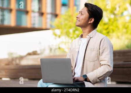 Asian man entrepreneur using laptop at park Stock Photo