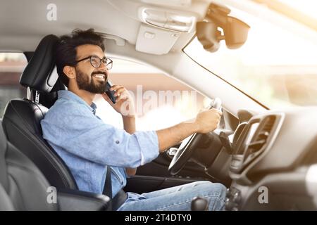 Cheerful handsome bearded young indian man driver talking on phone Stock Photo