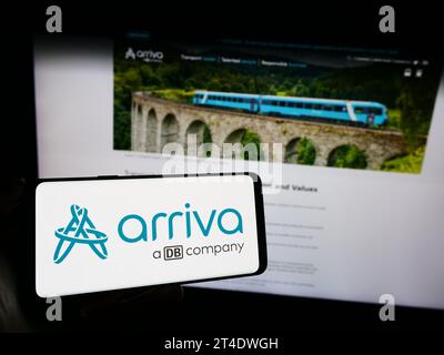 Person holding cellphone with logo of British public transport company Arriva plc in front of business webpage. Focus on phone display. Stock Photo