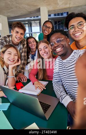 Group of multiracial students taking a selfie while gathering to study together at campus university Stock Photo