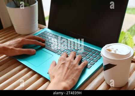 People working with a cup of coffee beside his laptop Stock Photo