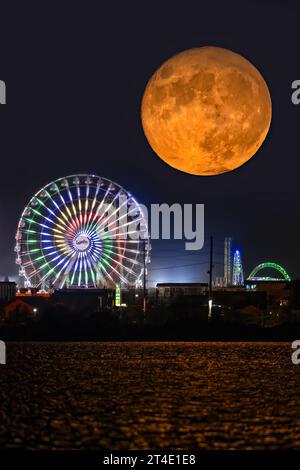 Super Blue Moon By Seaside - The rare super blue moon rises by Casino Pier ferries whell by Seaside Park in New Jersey. Stock Photo