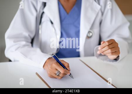 Cropped of woman doctor writing in medical chart Stock Photo