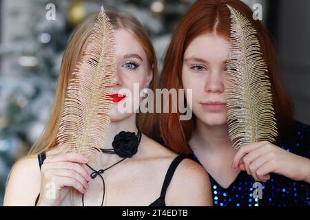 portrait of two beautiful girls. Models posing near decorated Christmas tree at New Year eve.  Stock Photo