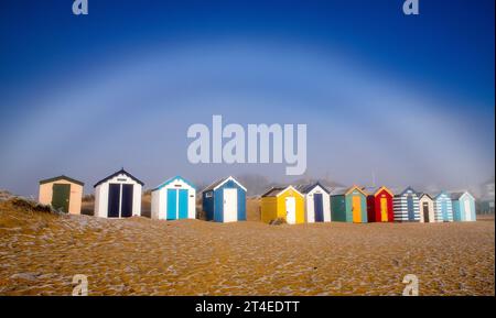 Fog Bow over the beach huts in Southwold, Suffolk England UK Stock Photo