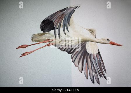 Mural graffiti at a high-rise skyscraper building in Langen, Hesse with painted flying stork in sky in silicate paint, copy space Stock Photo