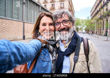 Selfie portrait smiling mature Caucasian tourist couple posing outdoor. Happy people in love sixties Stock Photo