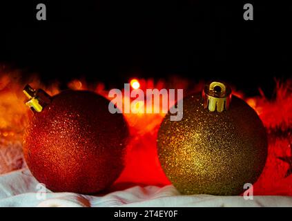 Two Christmas tree toys illuminated by red light garlands on a black background Stock Photo