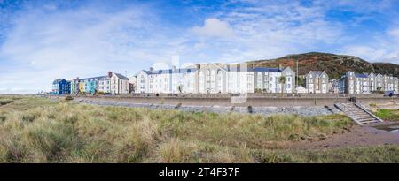 A multi image panorama of colourful hotels lining the promenade at Barmouth seen on 22 October 2023 under a blue sky. Stock Photo