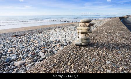 A rock stack seen on the promenade at Barmouth in Wales under a bright sky. Stock Photo