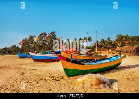 Colorful  fishing boats  and smallest houses of fishermen families among coconut trees (palm tree)  on the beach  in Gokarna,  Karnataka state. Stock Photo