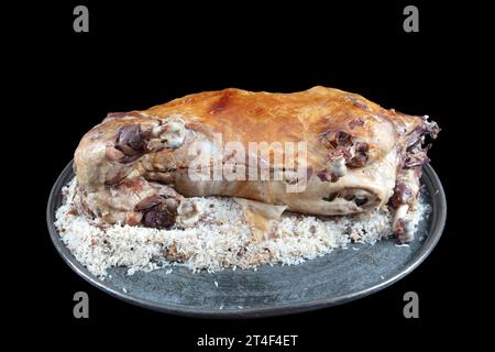 Turkish Cuisine Whole lamb carcass roasted on a spit. Roast whole lamb stuffed with rice pilaf. Roast whole lamb ready to serve on large tray. Stock Photo