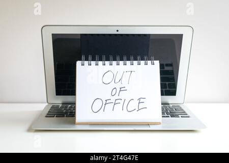 Out of office, written message on top of computer laptop. Stock Photo