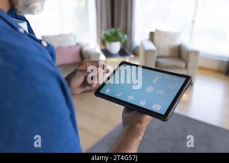 Midsection of senior caucasian man using tablet with smart home interface Stock Photo