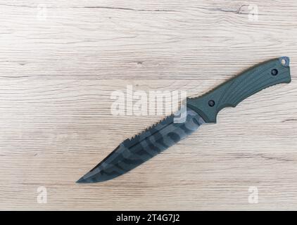 Hunting knives placed on a wood grain floor, top angle shot. Stock Photo