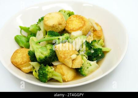 Thai food, Stir-fried broccoli and deep-fried Egg-Tofu with oyster sauce. Healthy food image on white background, view side and above a 45-degree angl Stock Photo