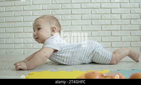 A little baby crawling on the floor in light room Stock Photo