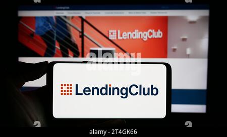 Person holding cellphone with logo of US financial services company LendingClub Corporation in front of business webpage. Focus on phone display. Stock Photo
