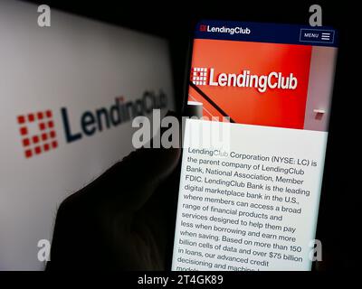 Person holding cellphone with webpage of US financial services company LendingClub Corporation in front of logo. Focus on center of phone display. Stock Photo