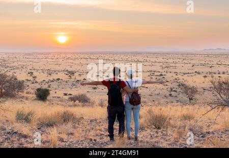 Young couple enjoying the sunset in an African landscape Stock Photo
