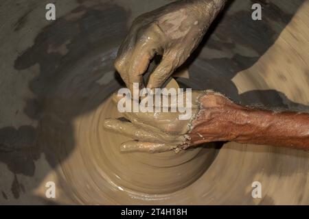 Indian potter making small pot or Diya for Diwali with clay on potters wheel Hand work craft Stock Photo