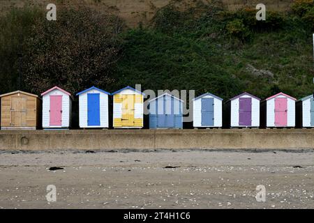 An idyllic beach scene featuring multicolored beach huts lined up in a row. Stock Photo