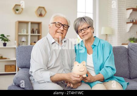 Portrait of happy senior married couple saving their family budget and saving for future. Stock Photo