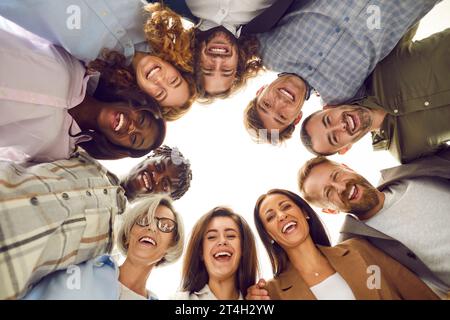 Diverse team of happy smiling business people and friends huddling and having fun Stock Photo
