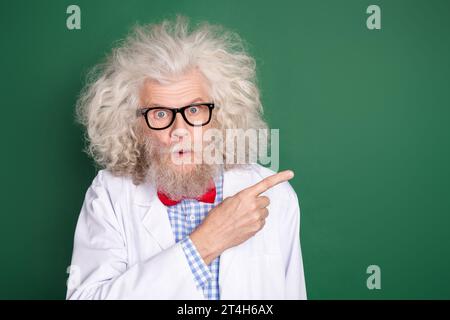 Portrait of impressed person staring camera direct finger empty space promotion isolated on dark green color background Stock Photo