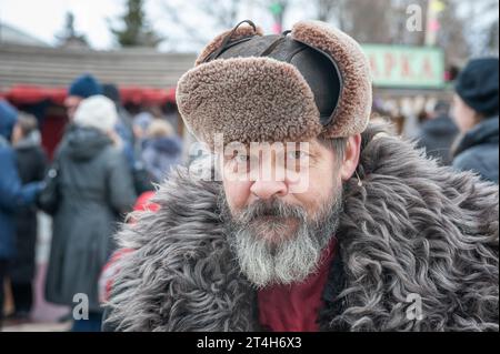 Portrait of a bearded man in a hat with earflaps and a sheepskin coat. A costumed character at Maslenitsa. Kolomna, presentation of the Pastille Museu Stock Photo