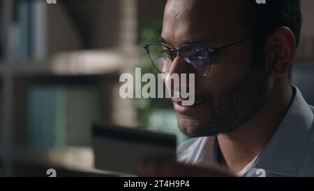 Close up joyful happy man office worker in glasses shopping online with computer businessman with laptop and credit card paying in internet bank Stock Photo